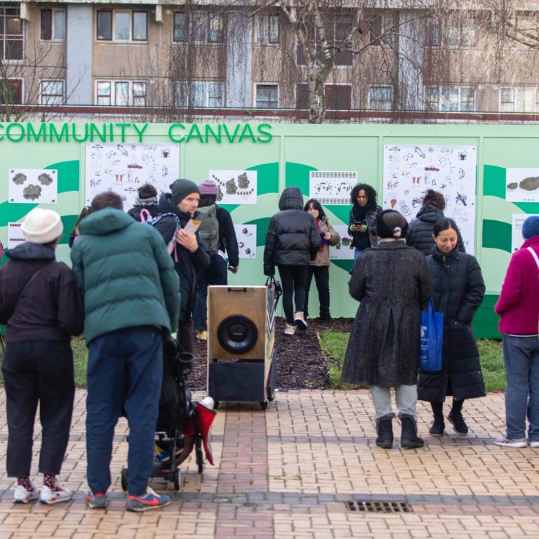 Image courtesy of Haringey Council (Arts at the Farm, 2024) People gathering around a green mural and community exhibition, engaging and sharing ideas.